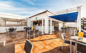 An outdoor café area with tables and chairs, a bar, and a sheltered seating area. - Globales Aparthotel Bouganvilla (Sant Llorenc des Cardassar)