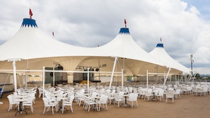 A large outdoor seating area with white tables and chairs under white canopies with blue tops. - Globales Aparthotel Bouganvilla (Sant Llorenc des Cardassar)
