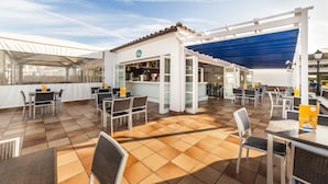 An outdoor patio area with tables and chairs, a bar, and a covered seating area. - Globales Aparthotel Bouganvilla (Sant Llorenc des Cardassar)
