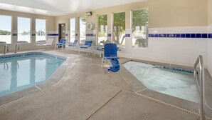 Piscina com cadeiras azuis e escorrega aquático.