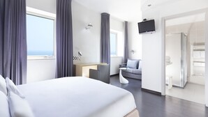 A modern hotel room with a large bed, a desk, a sofa, and a TV. - Club Meeting Hotel (Rimini)