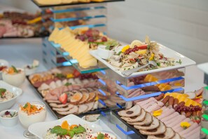 A buffet with various food items including sliced meats, cheeses, and fruits. - Express Kraków Hotel (Kraków)