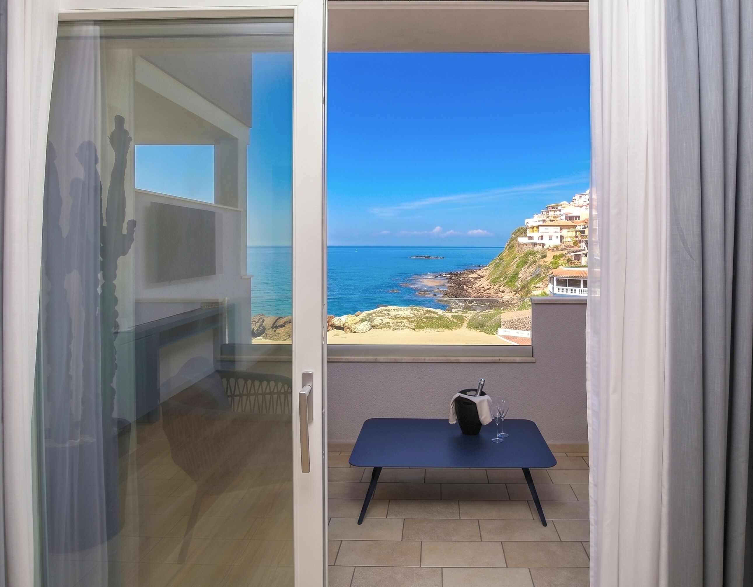 Un balcon avec vue sur la mer et les bâtiments.