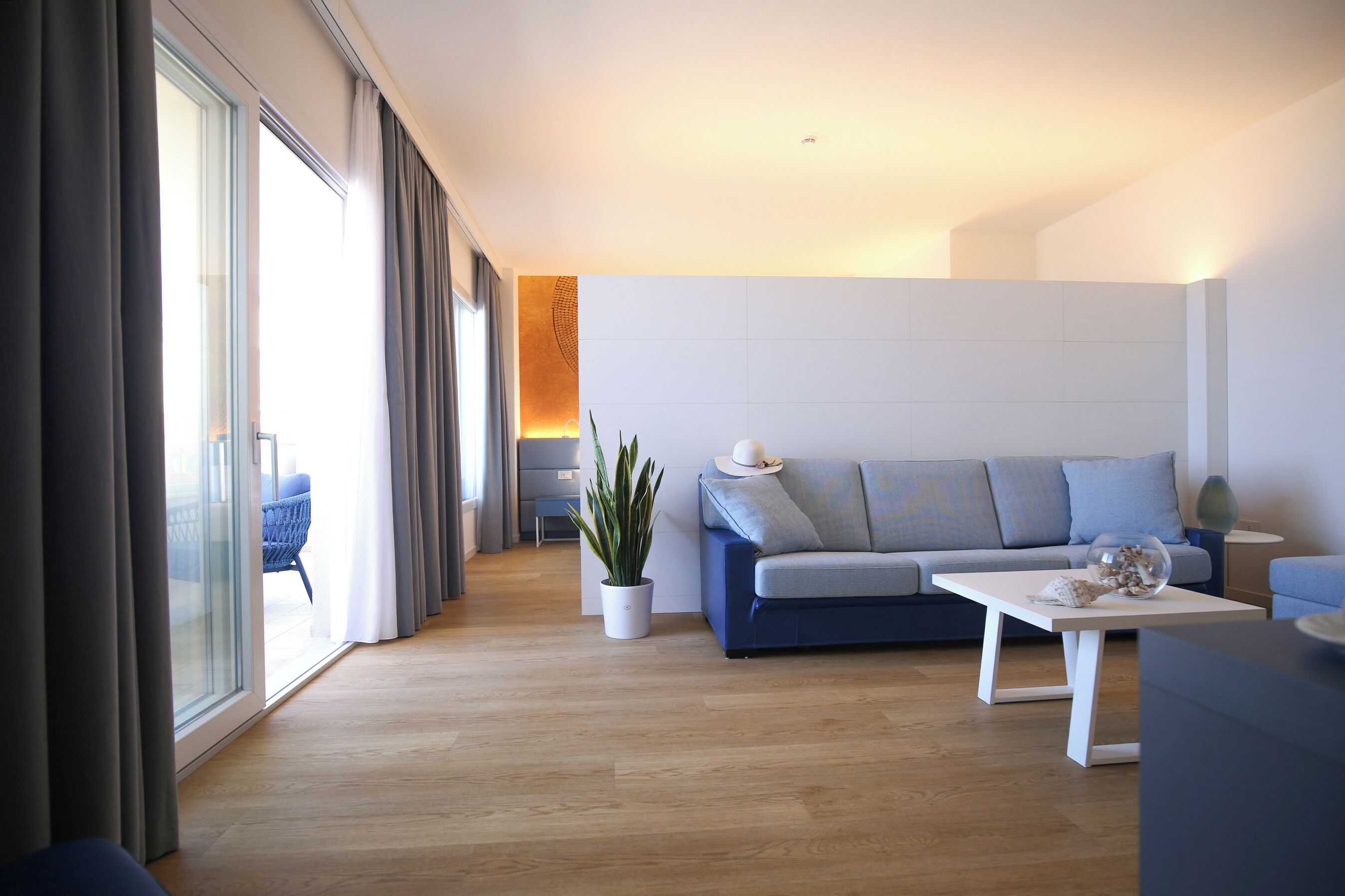 A modern living room with a sofa, a coffee table, and a potted plant.