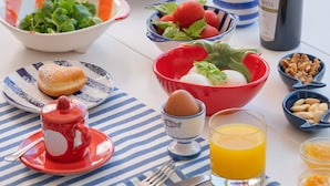 A breakfast table with croissants, eggs, and juice. - Le Terrazze - Adults Only (Conca dei Marini)