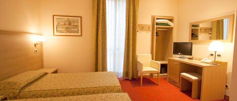 A hotel room with two beds, a desk, a chair, a television, and a mirror.