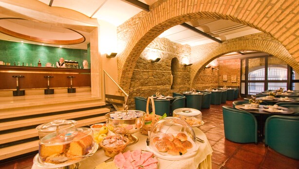 Montaje de bufé con diversos alimentos, una zona de bar y arreglos de asientos.