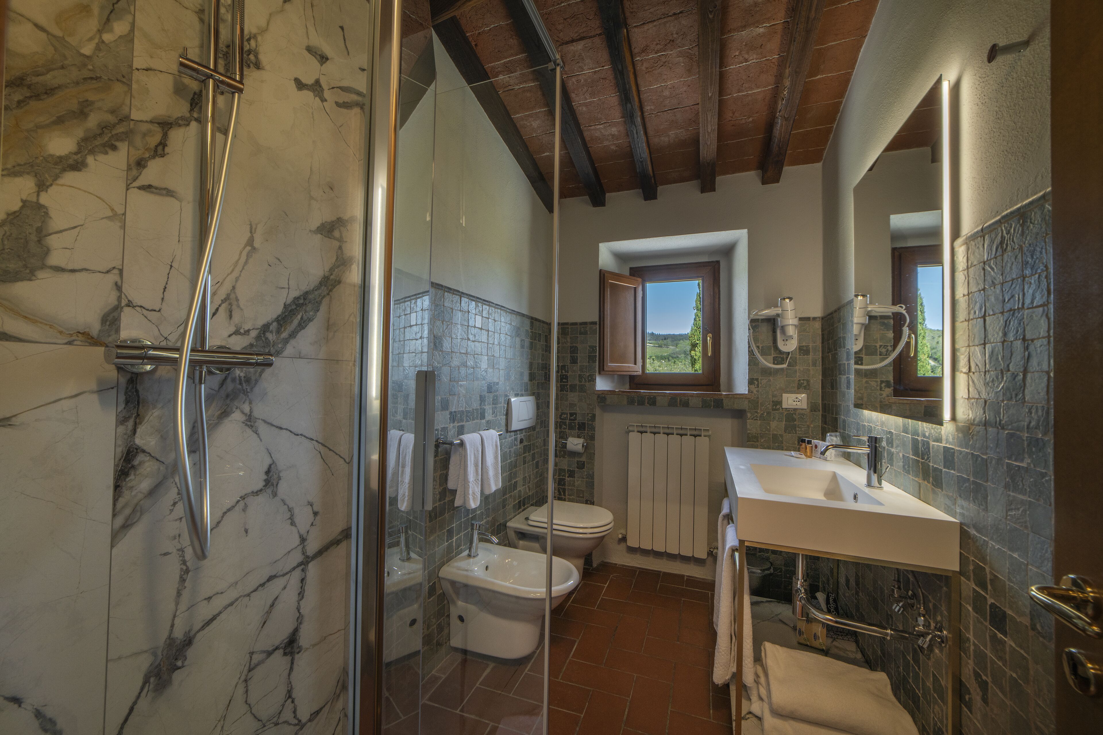 A bathroom with a shower, toilet, and sink.