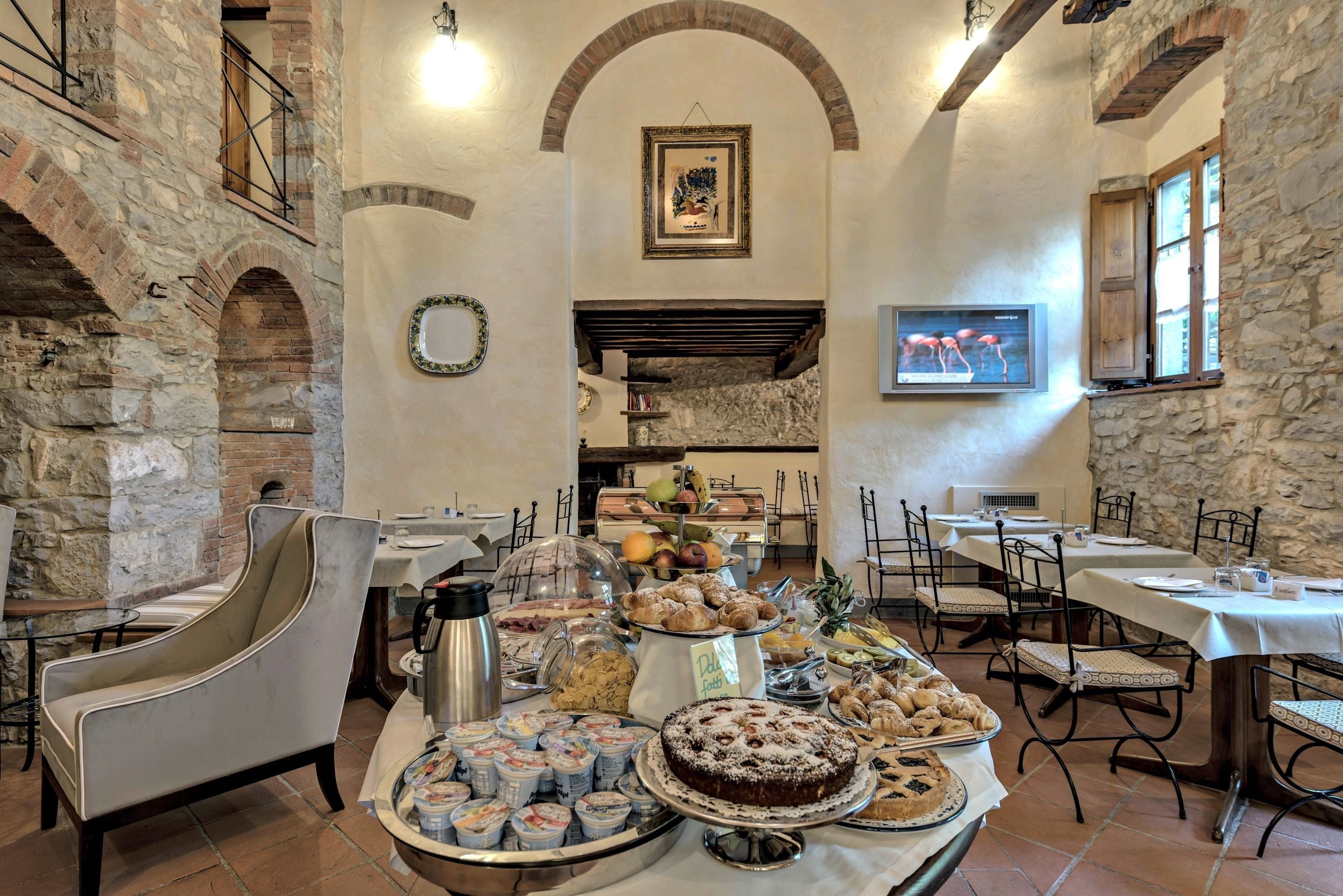 A dining area with stone walls, a fireplace, and a variety of food and drinks.