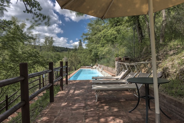 Una piscina al aire libre, camas de piscina gratis, sombrillas