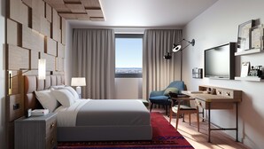 Habitación de hotel moderna con cama, escritorio, silla y una ventana grande con vistas a la ciudad.