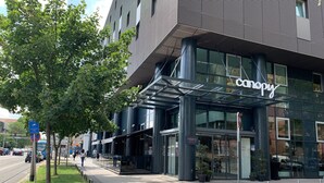 Un edificio moderno con fachada de vidrio y el nombre "canopy" en la entrada.