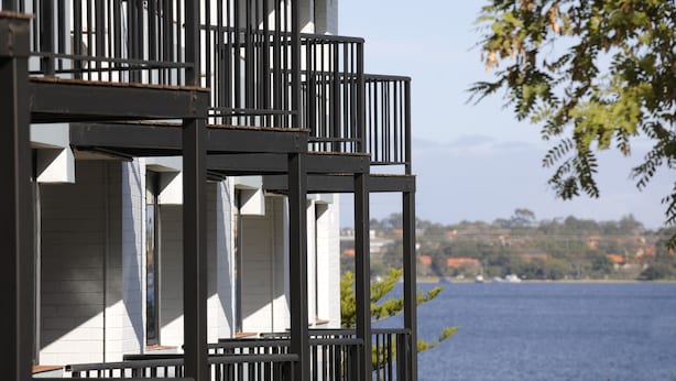 Un immeuble à plusieurs étages doté de balcons donnant sur une étendue d’eau.