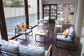A modern outdoor seating area with wooden flooring, white chairs, and sofas with cushions. - Travel Inn Flats Santo Andre (Santo André)
