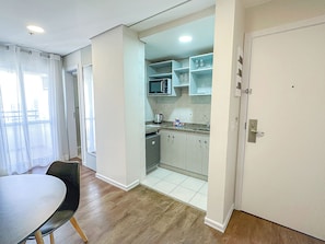 A compact kitchen with a microwave, cabinets, and a coffee maker. - Travel Inn Flats Santo Andre (Santo André)