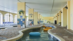 An indoor swimming pool with a brick border, lounge chairs, and a sign that reads "KEEP OFF ISLAND". - Camelot By The Sea by Oceana Resorts (Myrtle Beach)