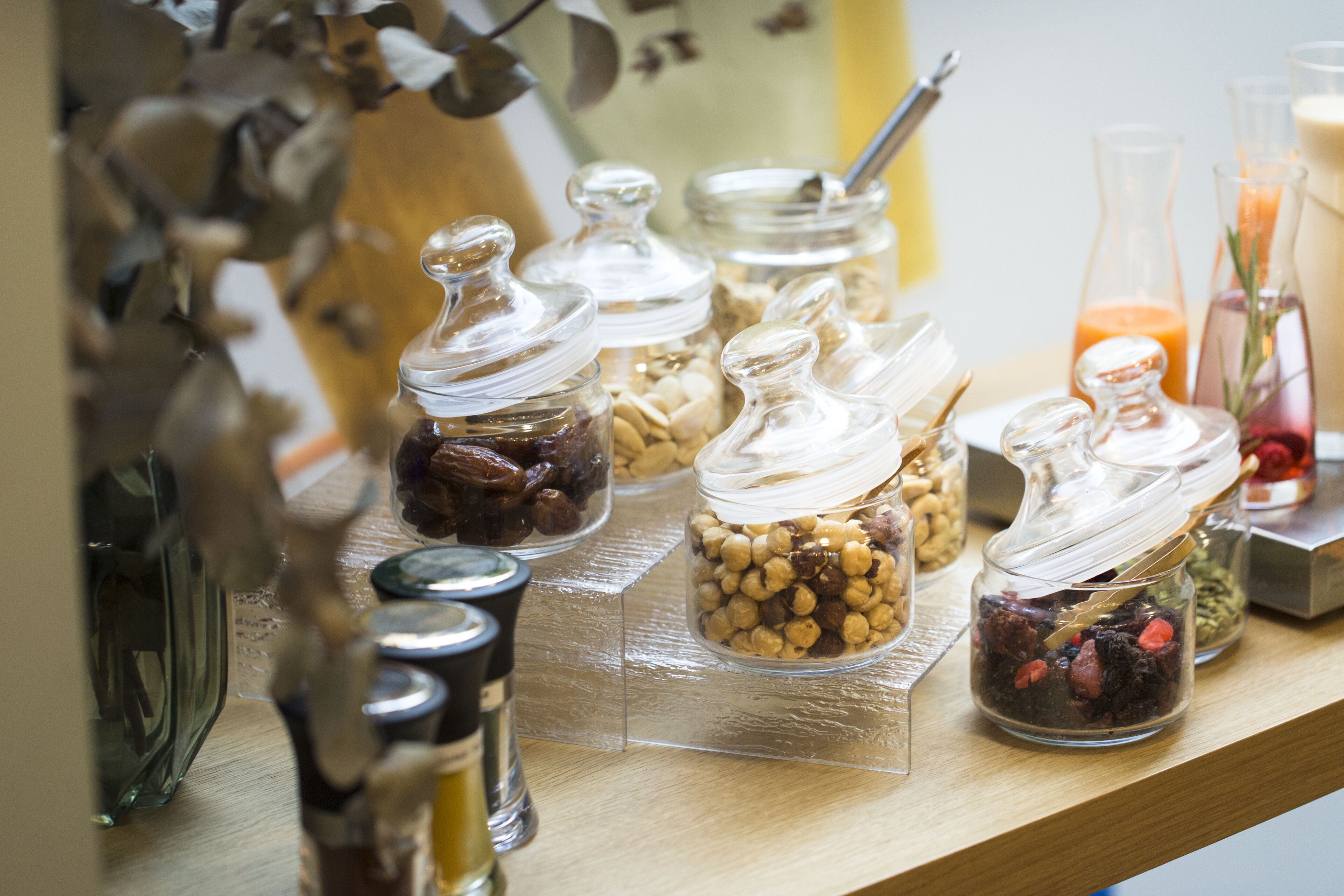 A shelf with various glass containers holding different food items.