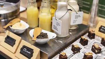 Presentación de alimentos que incluyen leche de almendras, postres de chocolate y un tazón con migas de galleta.