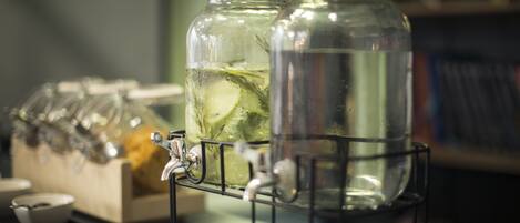 Two glass jars with metal lids on a metal stand, containing clear liquid and ice cubes.