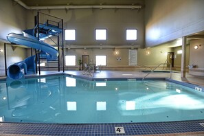 An indoor swimming pool with a blue slide and a 4 FT depth marker. - Quality Inn & Suites Grande Prairie (Grande Prairie)