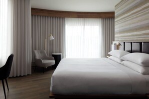 A hotel room with a large bed, a chair, a desk, and a lamp. - Quebec City Marriott Downtown (Québec City)