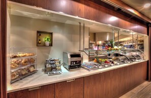 A buffet area with a variety of food items, including fruits and pastries, and a coffee machine. - Quebec City Marriott Downtown (Québec City)