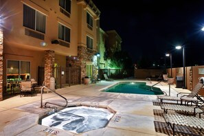 A pool area with hot tubs, lounge chairs, and a building with multiple windows and a stone pillar. - Fairfield by Marriott Inn & Suites Roswell (Roswell)