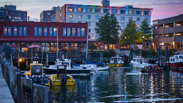 A waterfront marina with boats docked, buildings with multiple windows, and a red building with a visible restaurant. - Hilton Garden Inn Portland Downtown Waterfront (Portland)