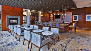 A hotel lobby with a bar area, seating arrangements, and a fireplace. - Hilton Garden Inn Portland Downtown Waterfront (Portland)