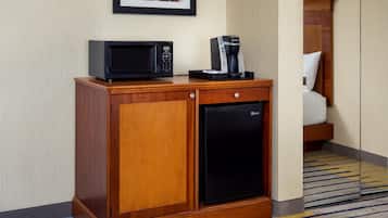 A compact minibar with a microwave, coffee maker, and refrigerator.