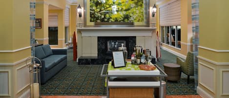 A lobby with a fireplace, a seating area, and a reception desk.