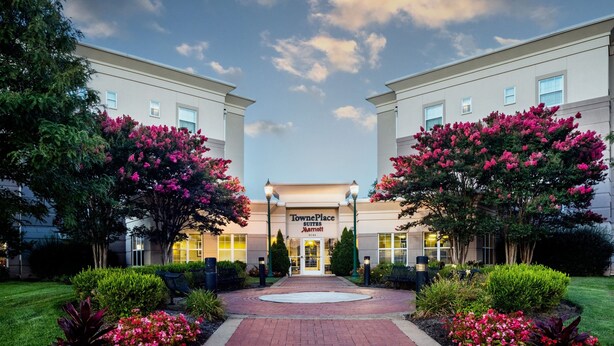 TownePlace Suites by Marriott with a brick pathway leading to the entrance, surrounded by well-maintained landscaping and trees. - TownePlace Suites by Marriott Springfield (Springfield)