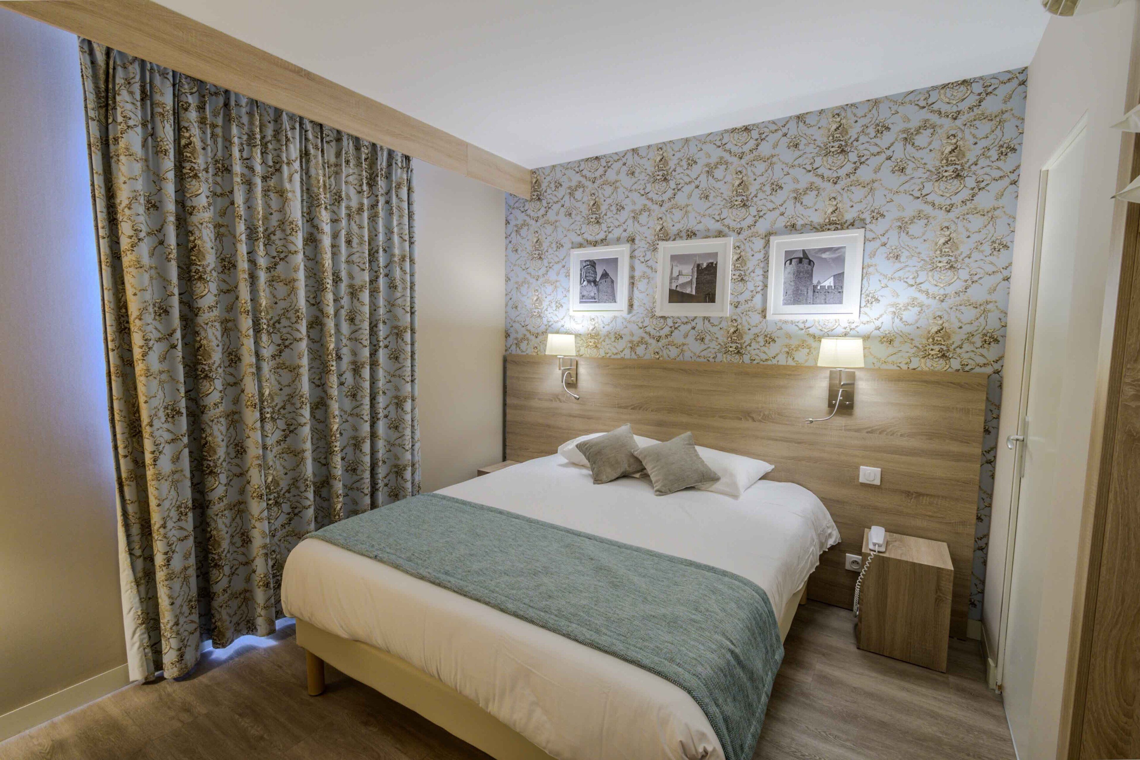 A neatly arranged hotel room with a large bed, a wooden headboard, and two bedside lamps.