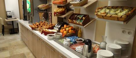 A buffet with various food items and condiments.