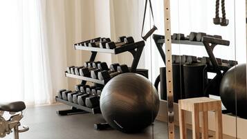 A gym with exercise equipment, including dumbbells, kettlebells, and exercise balls.