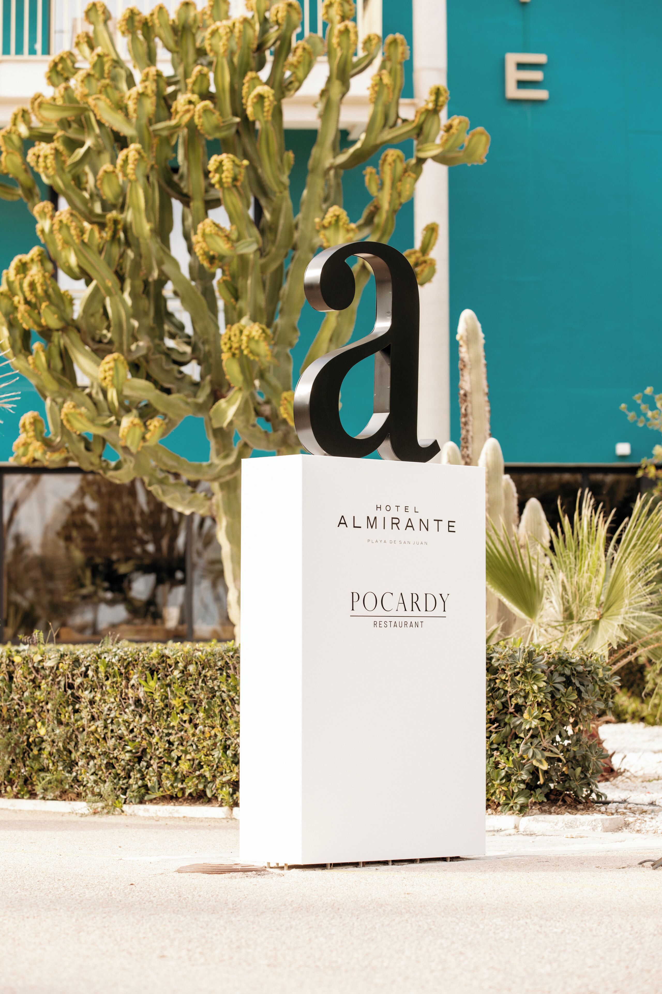 Een bord met de letter 'a' en de namen 'Hotel Almirante' en 'Pocardy Restaurant' ter aanduiding van een locatie.