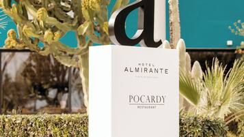 Een bord met de letter 'a' en de namen 'Hotel Almirante' en 'Pocardy Restaurant' ter aanduiding van een locatie.