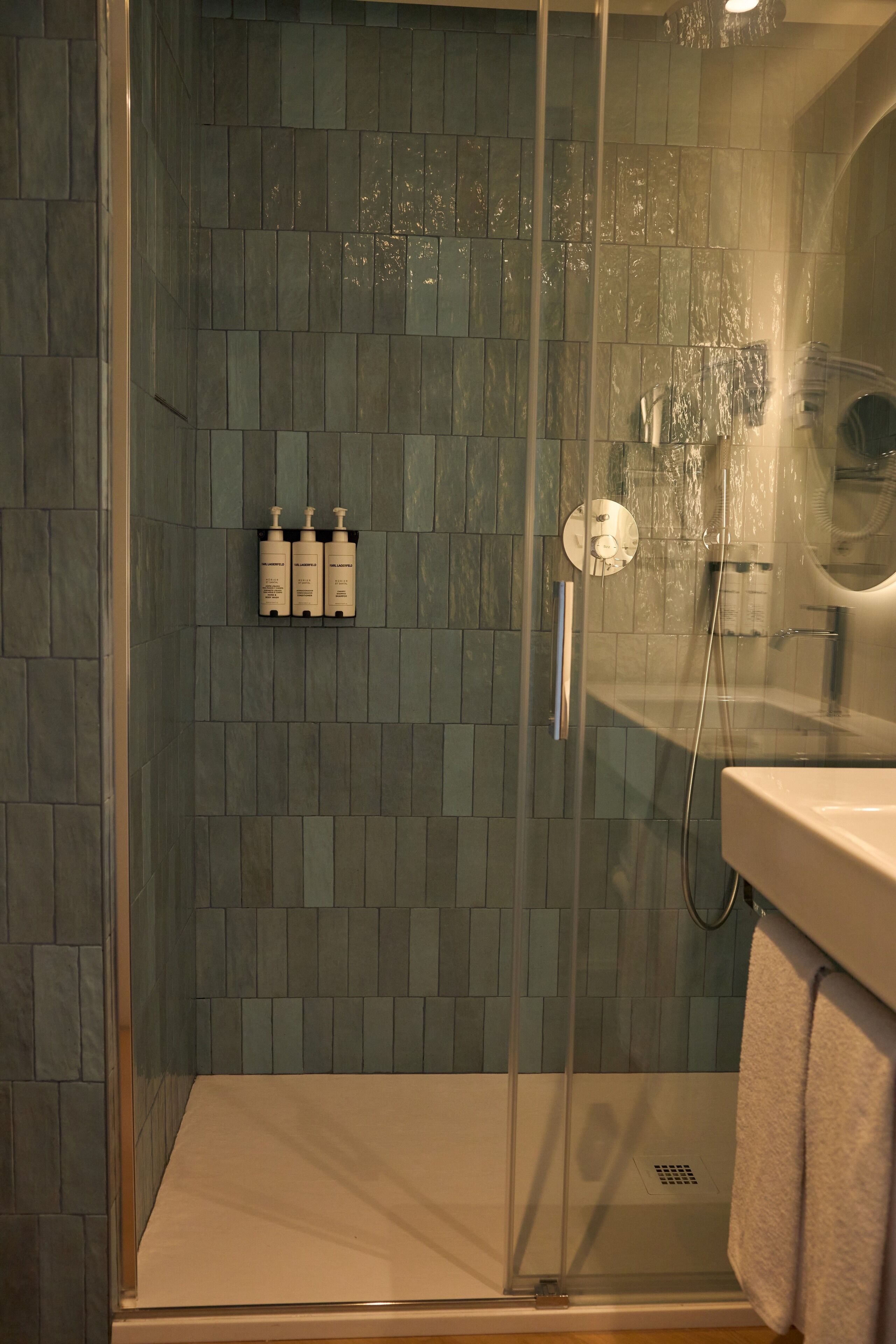A glass-enclosed shower area with a tiled wall, a glass door, and a visible showerhead.