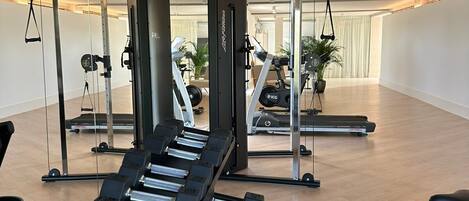 Ett gym med utrustning för styrketräning, löpband och träningsmaskiner.