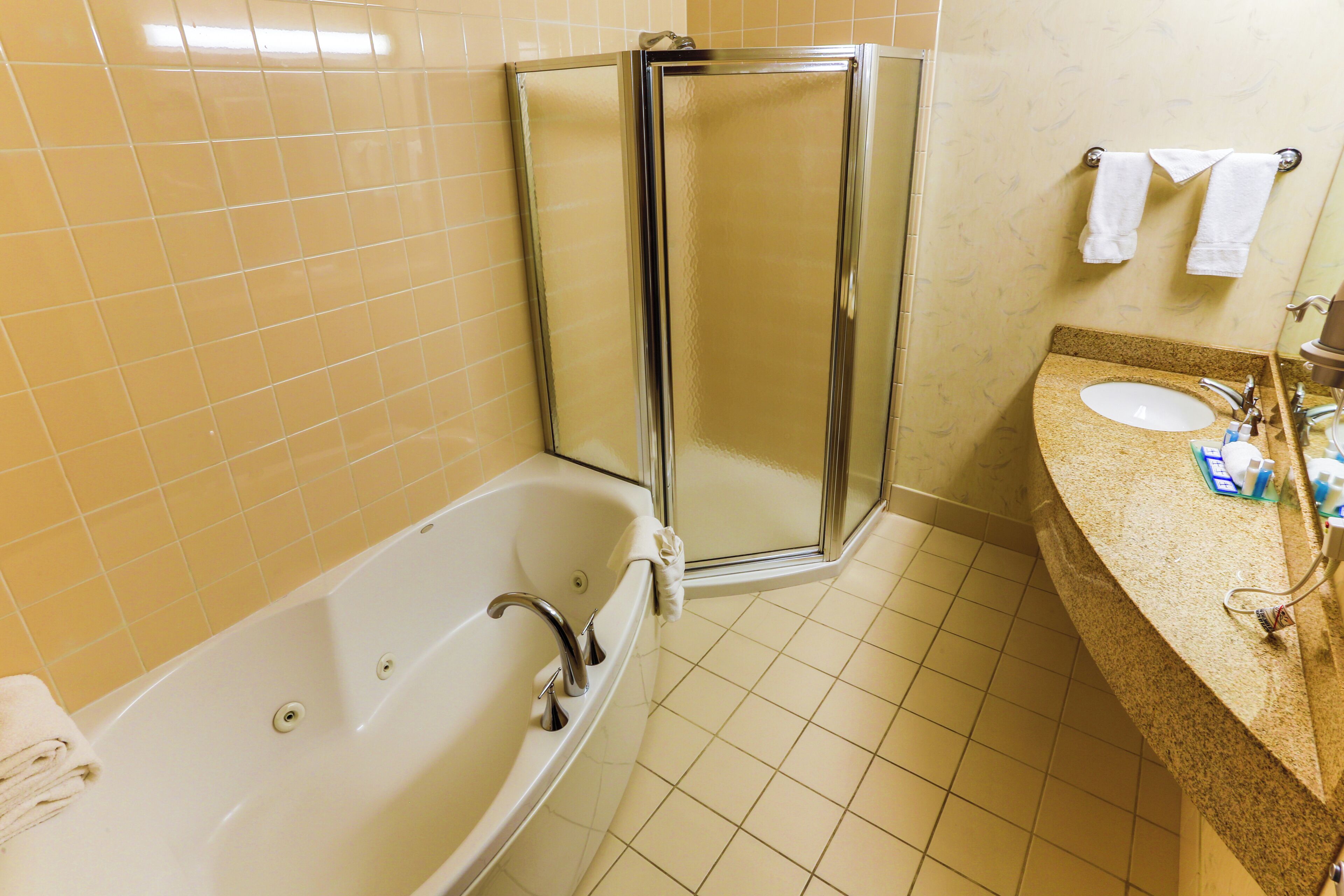 Une salle de bain équipée d’une baignoire, d’une douche à parois de verre, d’un lavabo et d’un porte-serviettes.