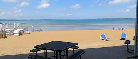 Een privéstrand, ligstoelen aan het strand, parasols, strandlakens