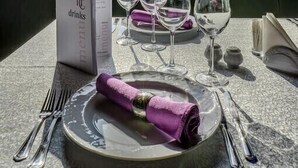A table set for two with a menu, wine glasses, and cutlery. - Hotel Capitol (Bucharest)