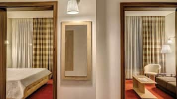 A hotel room with a bed, a mirror, a desk, and a chair.