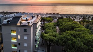 A hotel with a rooftop terrace overlooking the sea, a pool area, and lush greenery. - Hotel Cristallo (Giulianova)