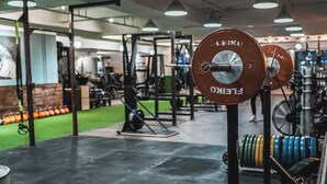 Une salle de sport équipée de matériel de musculation, notamment des barres et des poids.
