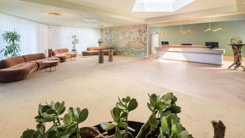 A spacious living area with a sofa, coffee table, and a reception desk.