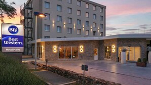 Exterior do Hotel Best Western Mainz, com fachada de pedra, várias janelas e área de entrada ajardinada.