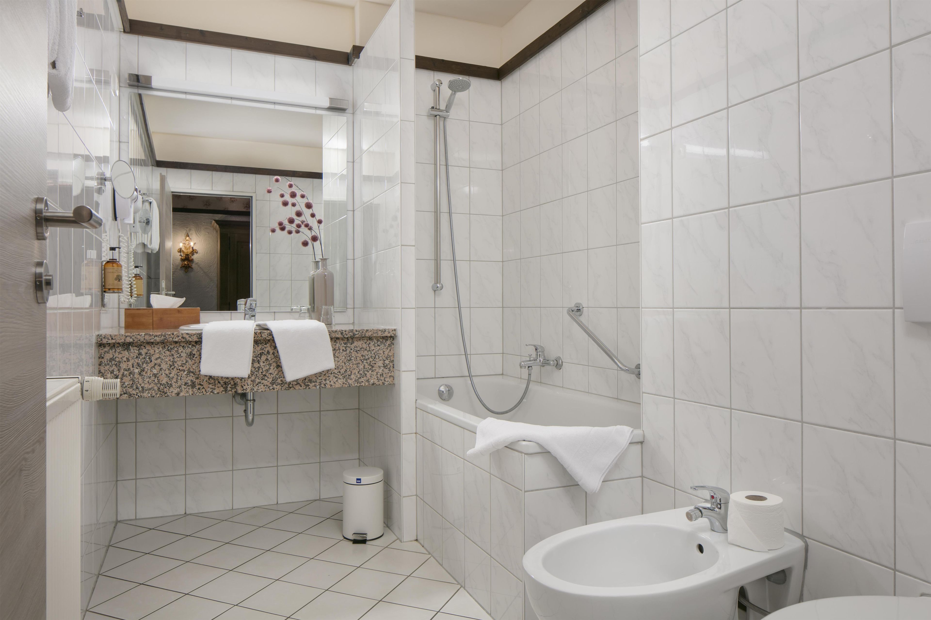 A modern bathroom with a shower, sink, and toilet.