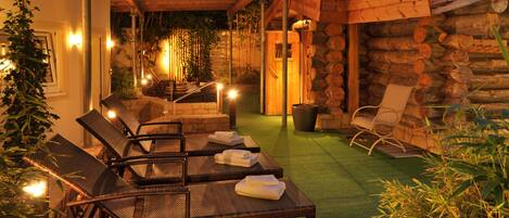An outdoor seating area with wicker chairs and a green artificial turf.