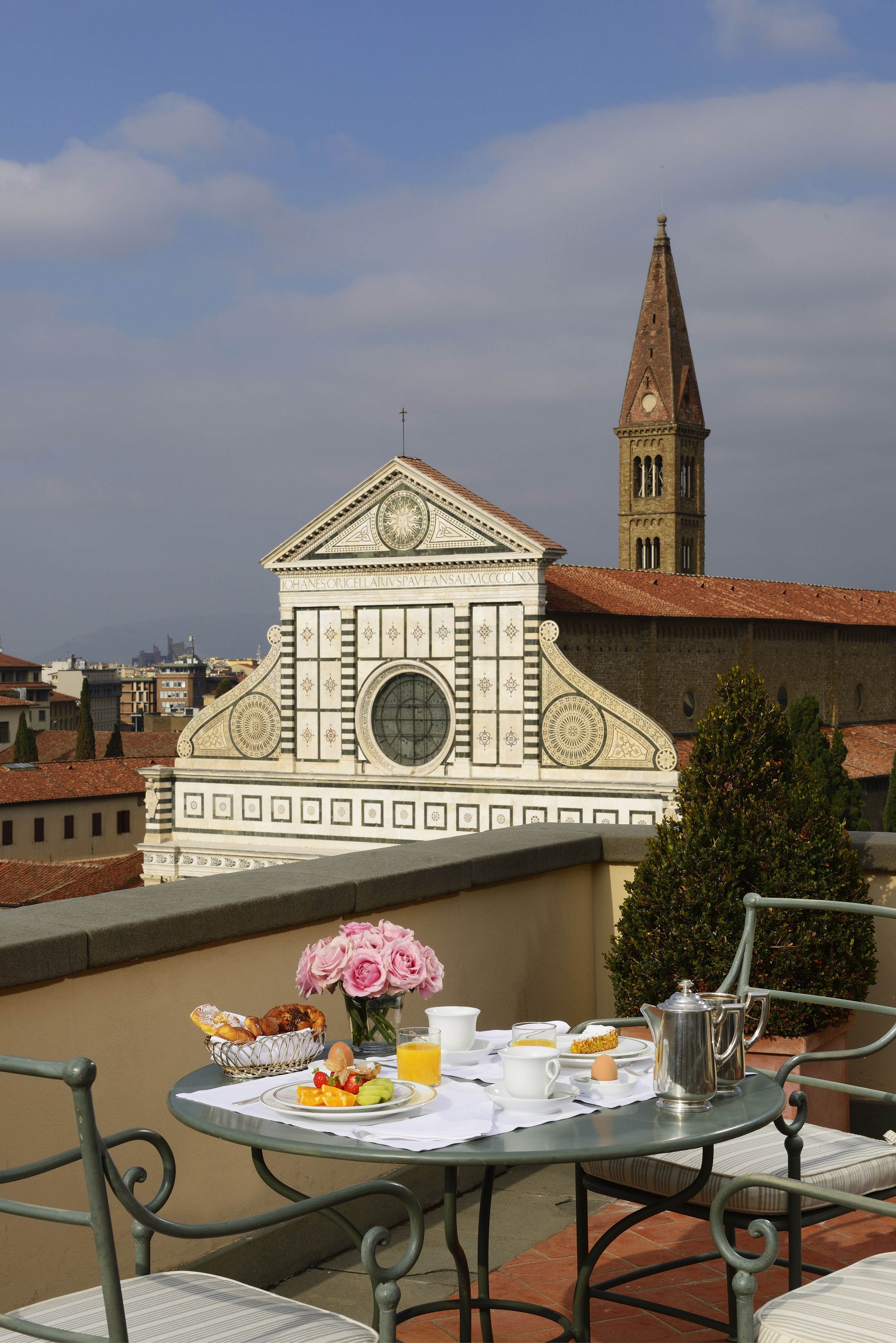 A table with breakfast items and a view of a historic building with a clock tower.